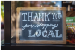 A signboard with the words shop local written on it.